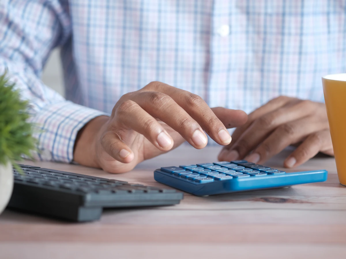 Manos usando una calculadora sobre un escritorio